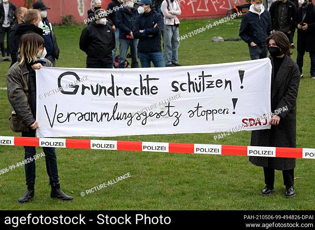 06 May 2021, North Rhine-Westphalia, Duesseldorf: Demonstrators hold a banner with the inscription ""Protect basic rights! Stop the law of assembly!"" in their...