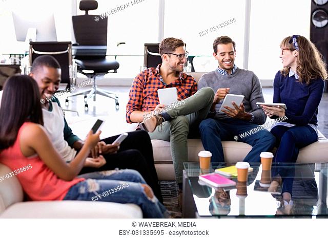 Smiling business people sitting on sofa