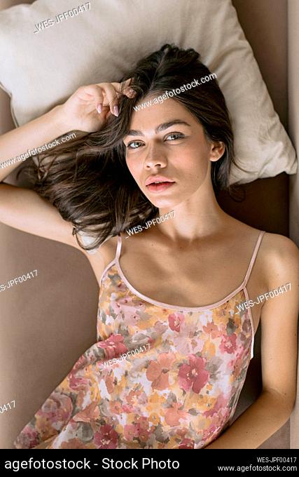 Portrait of beautiful young woman lying in bed