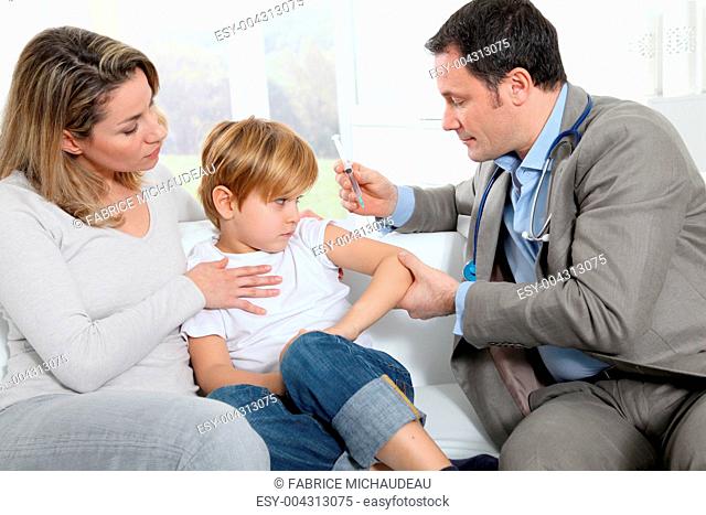 Doctor doing vaccine injection to little boy