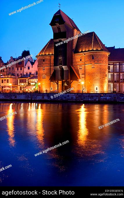 The Crane in Old Town of Gdansk at night in Poland, medieval landmark and symbol of the city with reflection on Old Motlawa river