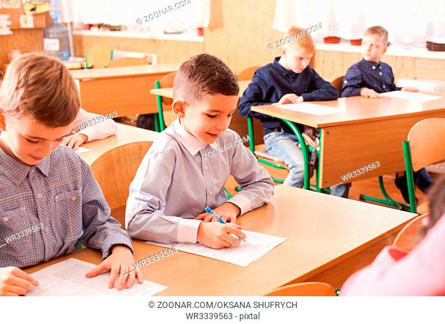 Children of primary school taking an exam writing school test