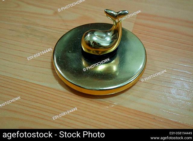 The decorative little golden pot with dolphin lid open, for room decoration. Golden pot on the vintage white background