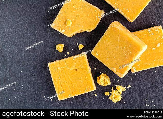 Fudge squares and crumbs isolated on black slate background