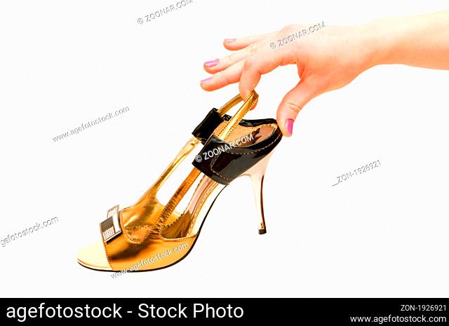 Hand holding woman shoe isolated on white