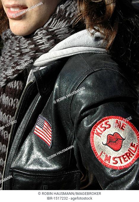 Young woman wearing a leather jacket with a patch Kiss me, I'm sterile