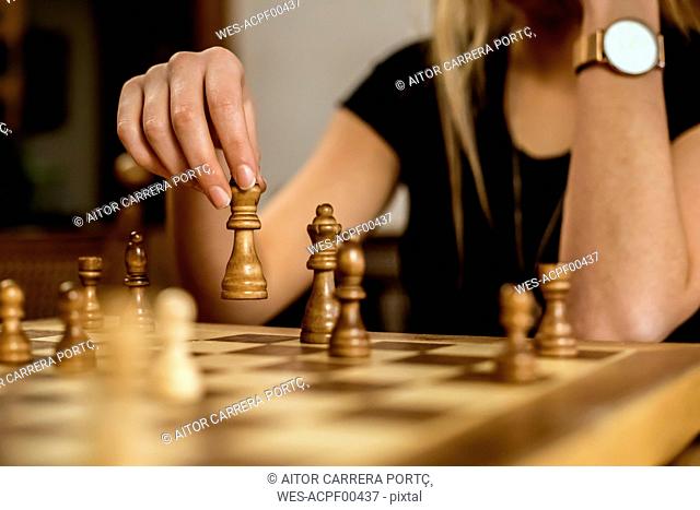 Close-up of a woman's hand moving a chess piece
