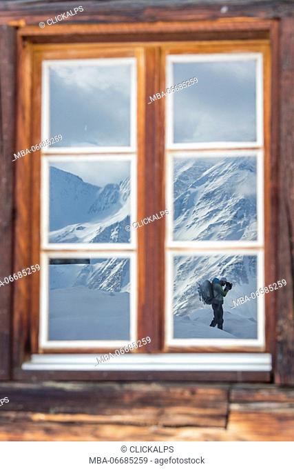 The photographer is reflected by window of the wooden hut Bettmeralp district of Raron canton of Valais Switzerland Europe