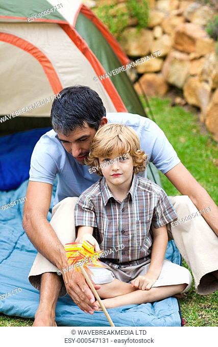 Father and son playing together in a tent