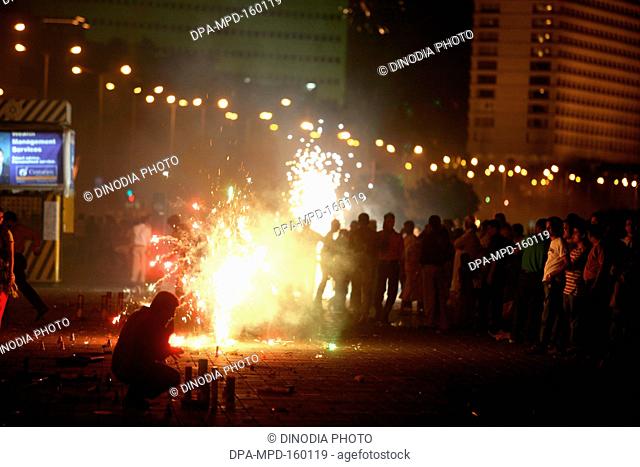 People celebrating Diwali Deepawali ; festival-of-lights by bursting fire crackers at Marine-drive in Bombay Mumbai ; Maharashtra ; India
