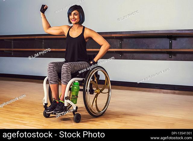 A paraplegic woman taking a break in a gymnasium after working out in a recreational facility: Sherwood Park, Alberta, Canada