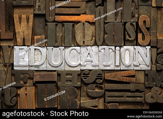 education word made from metallic letterpress blocks in mixed wooden letters