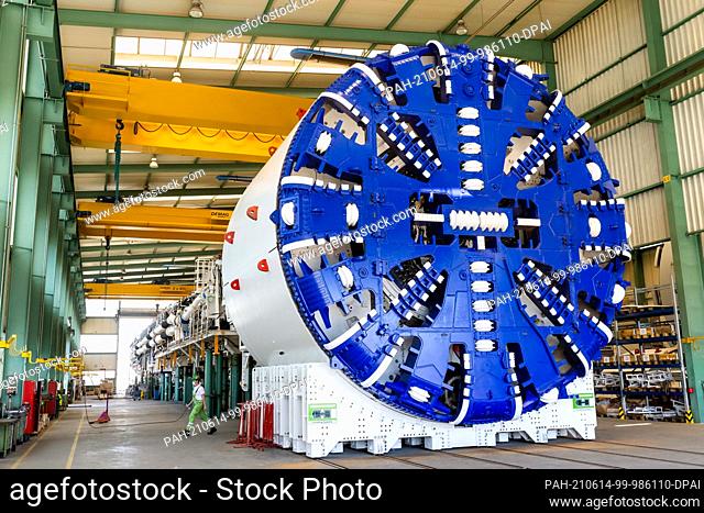 14 June 2021, Baden-Wuerttemberg, Schwanau: An employee walks along behind the cutting wheel of an almost fully assembled Herrenknecht tunnel boring machine