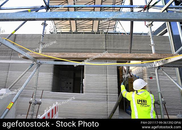 17 November 2020, Bavaria, Weißenhorn: Concrete is transported through a hose to the first floor of a building shell. The house