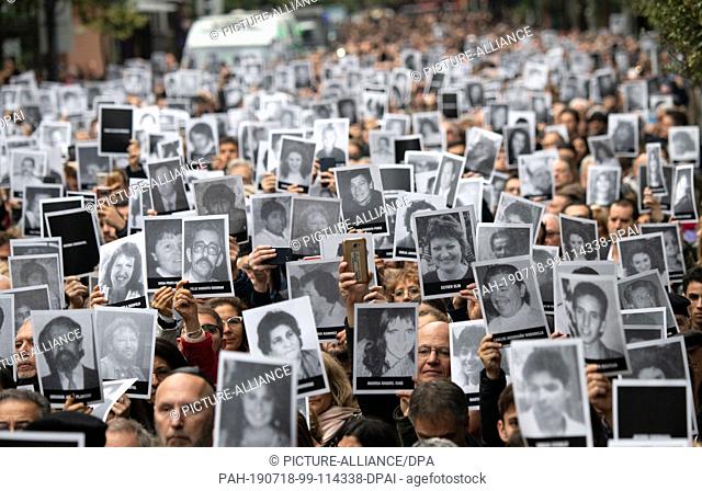 18 July 2019, Argentina, Buenos Aires: Hundreds of participants in a commemoration ceremony hold photos of the victims in their hands on the 25th anniversary of...
