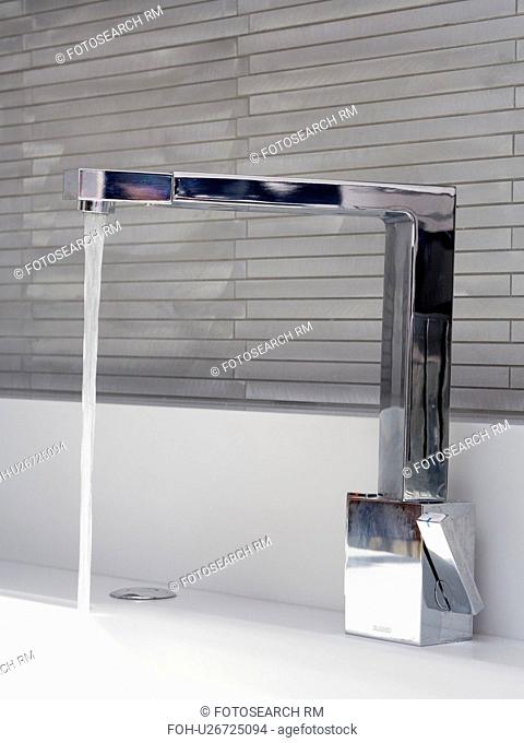 Close-up of angular chrome tap pouring water into sink