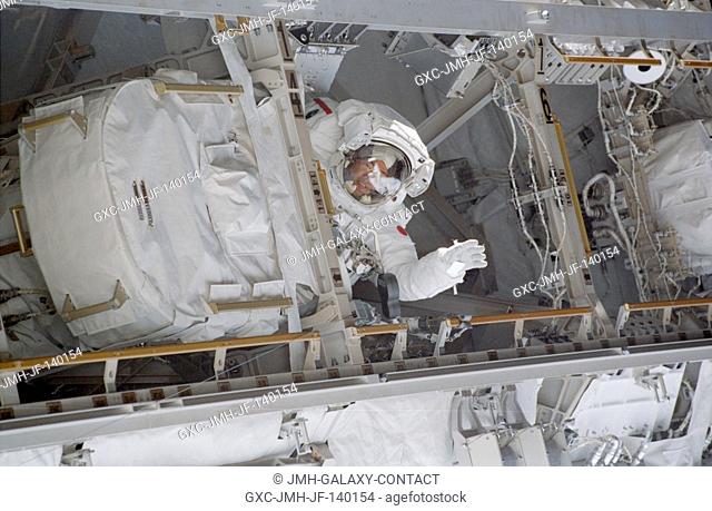 Astronaut Soichi Noguchi, STS-114 mission specialist representing Japan Aerospace Exploration Agency (JAXA), waves from within the foward side of the ISS P1...