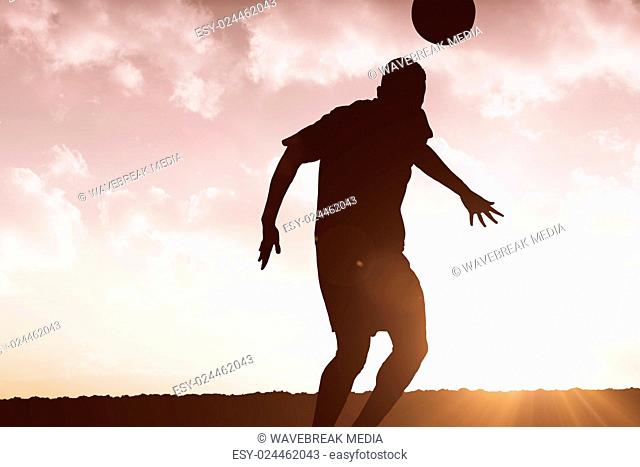 Composite image of football player hitting header