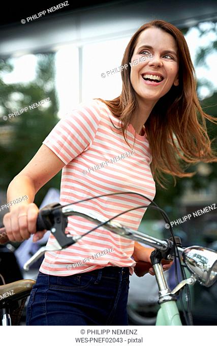 Happy woman with bicycle in the city