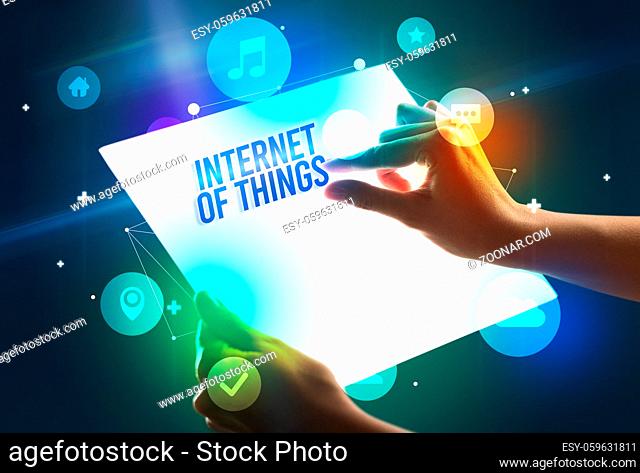 Holding futuristic tablet with INTERNET OF THINGS inscription, new technology concept