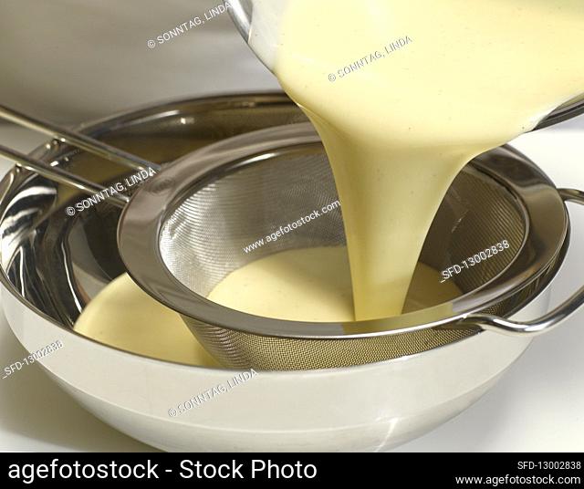 Passing vanilla cream through a sieve