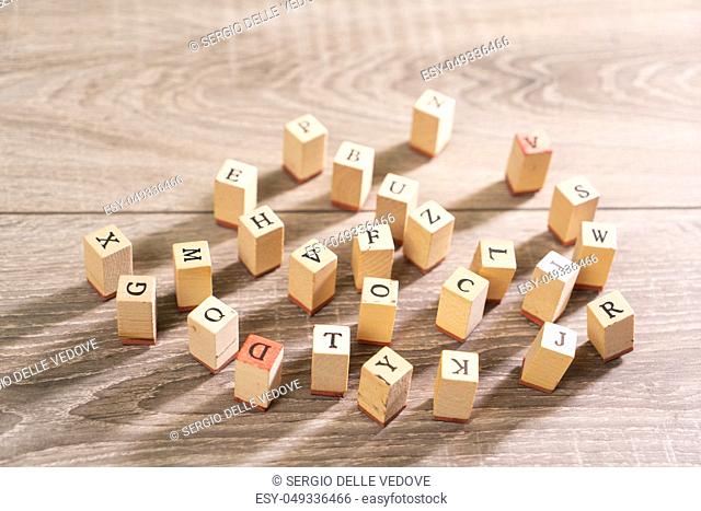 letters printed on wooden cubes scattered on the table
