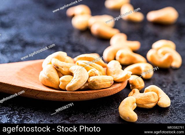 Roasted cashew nuts in wooden spoon