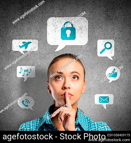 Portrait of attractive teenage girl with finger on lips on concrete background and application icons above head