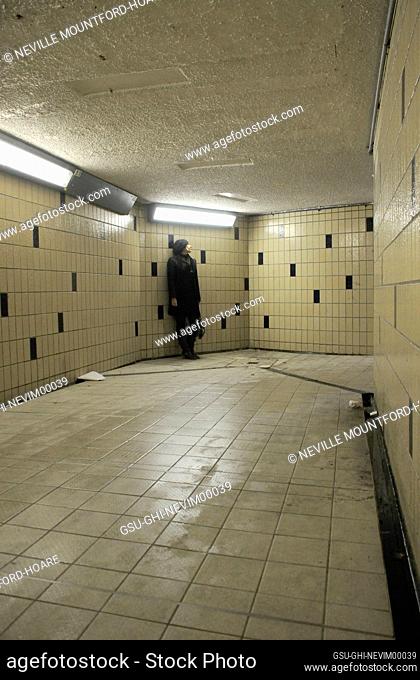 Young Adult Woman standing at end of Underground Pedestrian Tunnel