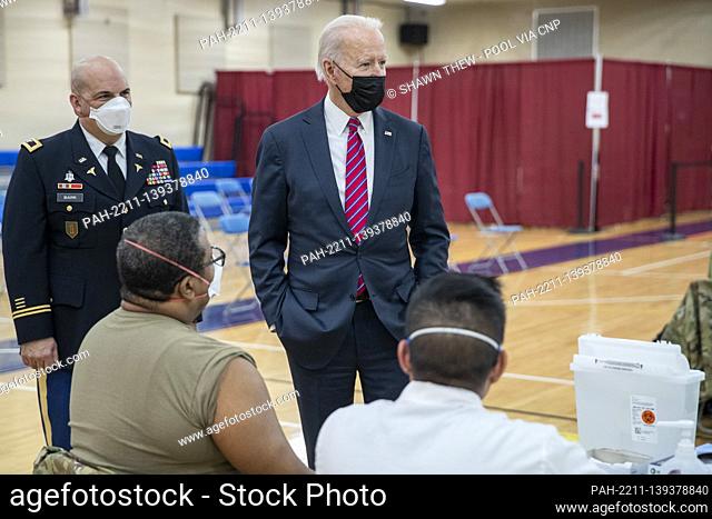 US President Joe Biden is is escorted by the Director of Walter Reed National Military Medical Center Colonel Andrew Barr (L) on a tour of a COVID-19...