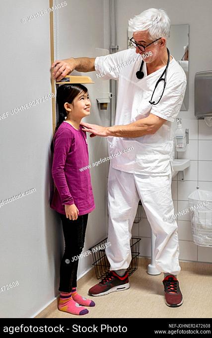 Doctor measuring girl's height