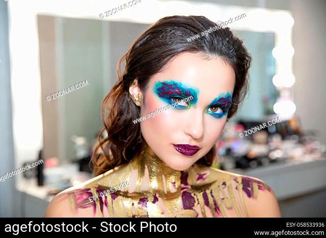 Young attractive brunette with creative make up and body painting