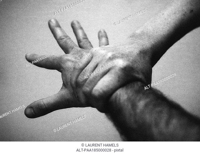 Hand holding wrist, close-up, b&w