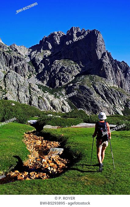 female wanderer next dried mountain creek in front of mountain scenery, France, Corsica, Restonica, Corte