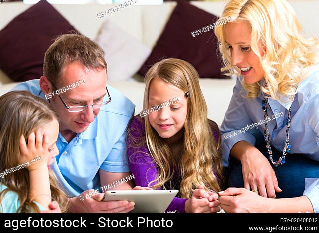 Familie spielt mit dem Tablet computer daheim