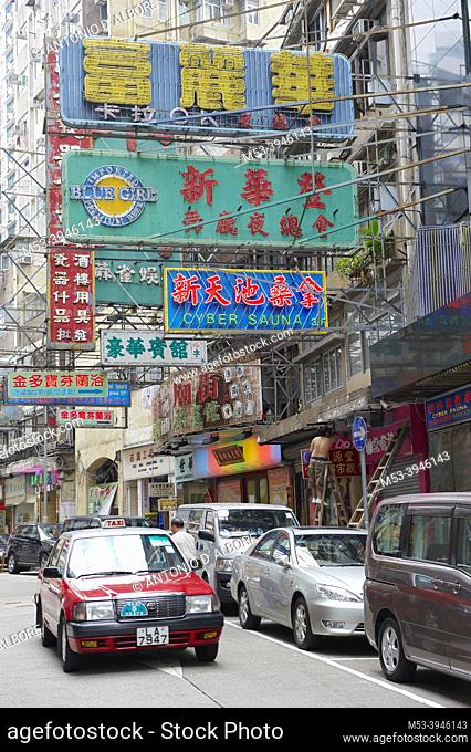 A taxi riding along Bowring Street. The place hosts multiple Karaoke and beauty parlors outlets. Yau Tsim Mong District. Kowloon Peninsula