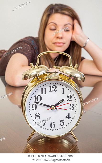 Young woman with an alarm clock