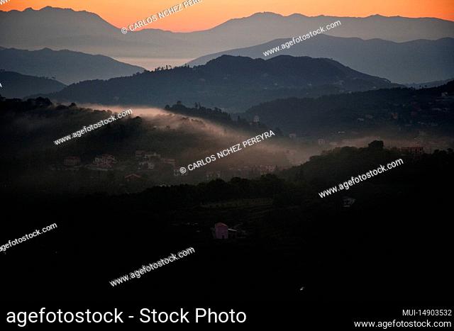Sunset in a mountain range with mountains backlit