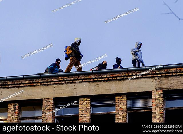 14 December 2023, Hesse, Frankfurt/Main: Activists stand on the roof of the Dondorf printing works. Police began clearing the squatted former Dondorf printing...