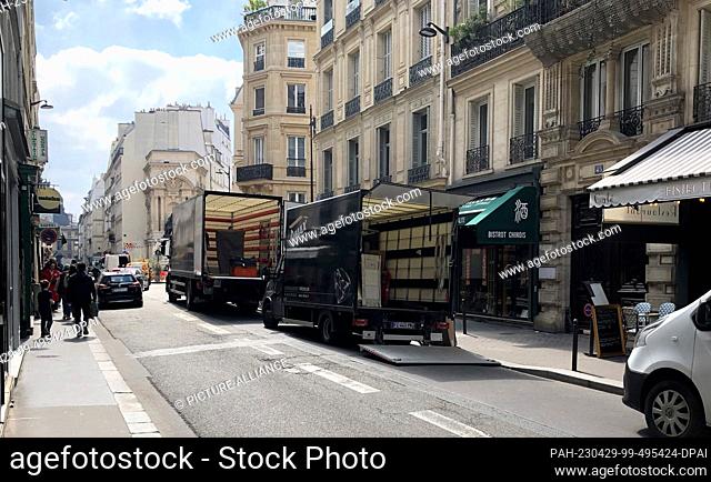PRODUCTION - 18 April 2023, France, Paris: Two moving vans are parked in the center of the city. (to dpa: ""Parisians are drawn to the provinces - home office...