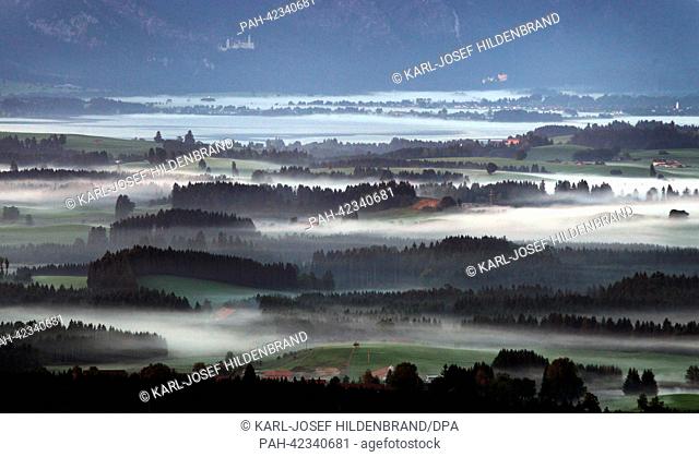 Early morning fog is visible in the valleys of the prealpine lands at the castles Neuschwanstein (L) and Hohenschwangau (R) near Fuessen, Germany