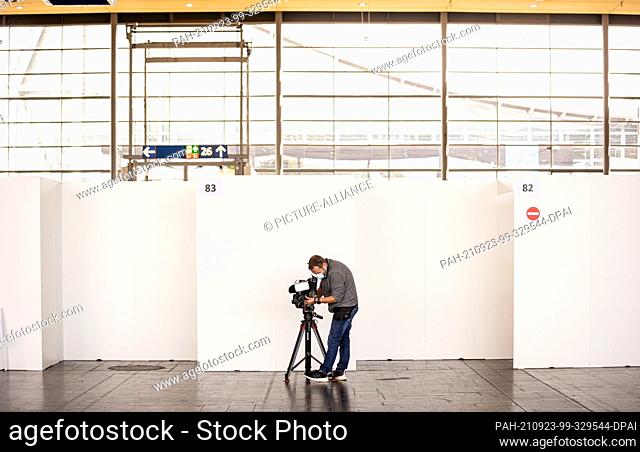 23 September 2021, Lower Saxony, Hanover: A cameraman films a waiting area at the vaccination centre on the exhibition grounds