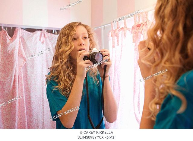 Teenage girl photographing self