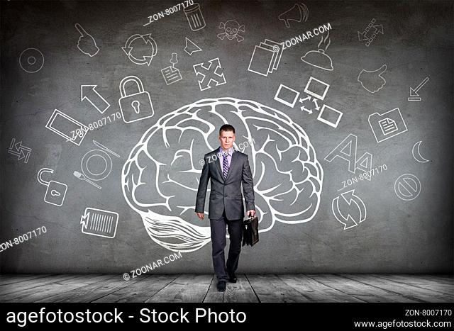 Woman stands beside big drawn brain on the gray wall