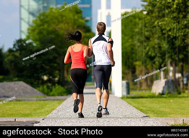 Urban sports - couple jogging for fitness in the city on a beautiful summer day
