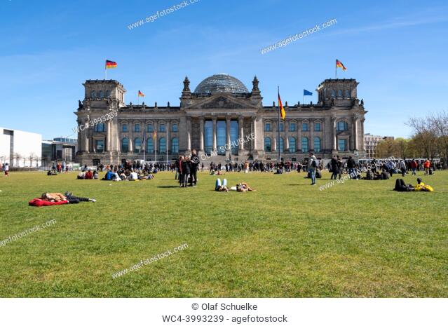 Berlin, Germany, Europe - People on the lawn in front of the Reichstag building in Mitte district, the Republic Square (Platz der Republik)