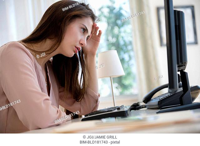 Frustrated Native American businesswoman working at computer
