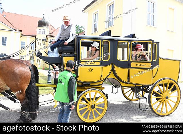 29 May 2023, Saxony, Hohenprießnitz, Bad Düben: Excursionists sit in a stagecoach from 1939 from the Kracht family business in the castle courtyard of the...