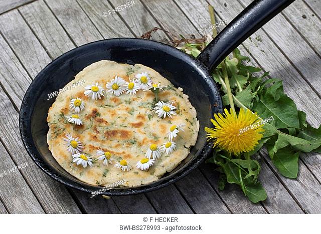 pancake with daisies and dandelion in a cast-iron pan, Germany
