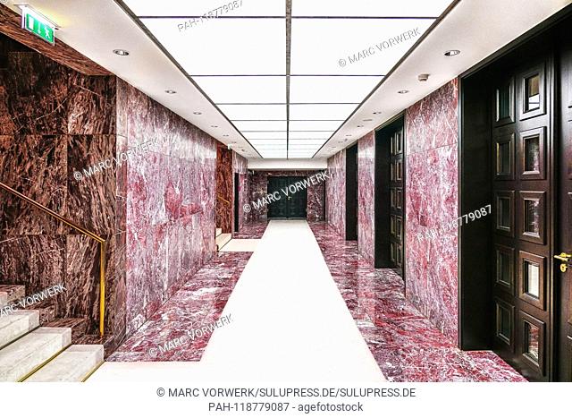 06.03.2019, an empty hallway, covered with large, red-mottled granite slabs with strikingly restless texture, heavy wooden double doors with cassettes and...